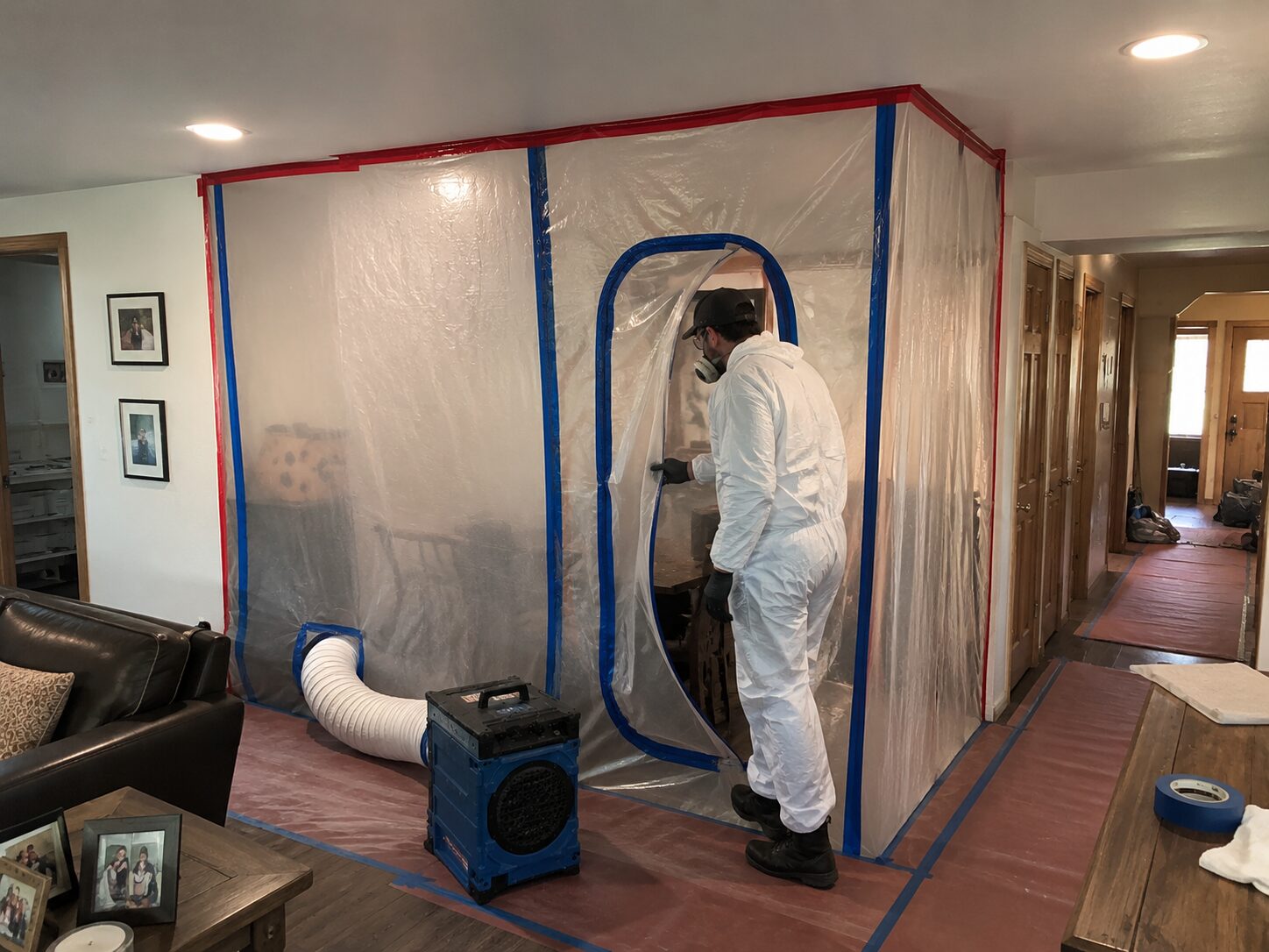 Containment barrier set up in a living room ahead of mold remediation