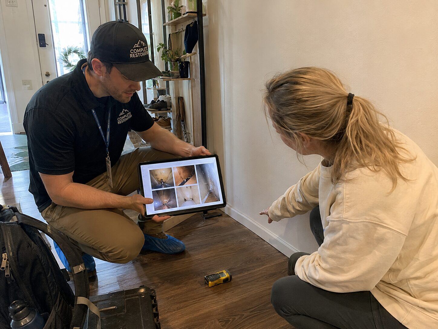 Complete Restoration technician reviewing inspection camera photos with a homeowner