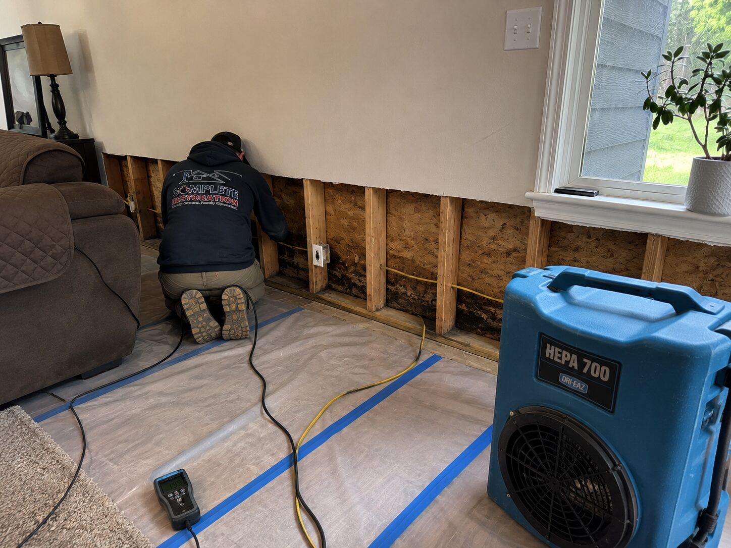 Wall opened to the studs with a HEPA air scrubber running during water damage repair